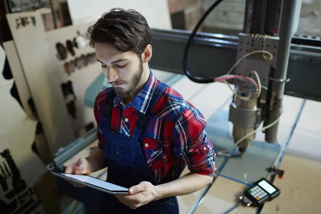 ingénieur avec une tablette travaillant sur une machine